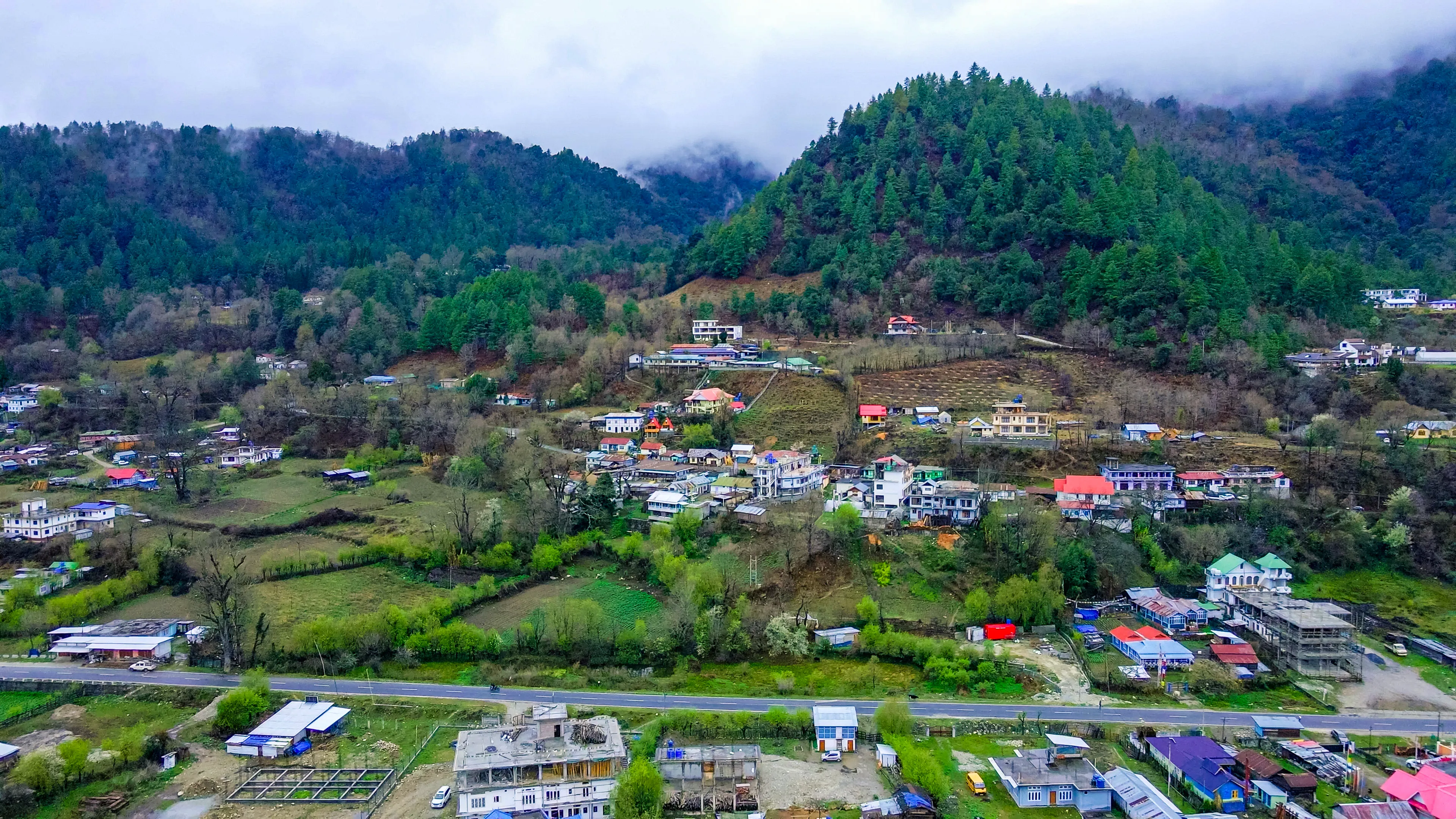 Aerial view of Shergaon village amid misty hills, Arunachal Pradesh